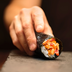 Hand on Sushi Roll